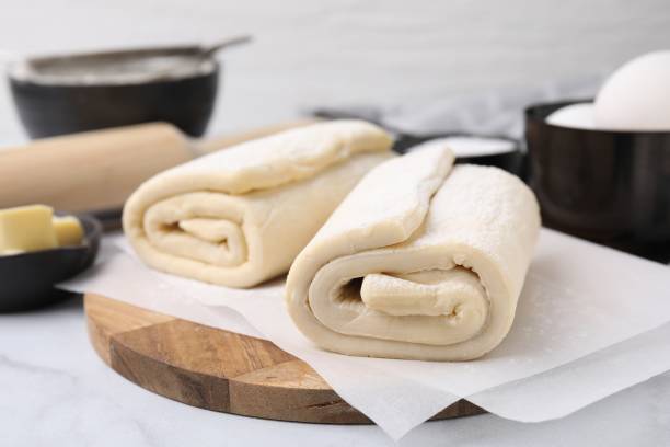 istock Raw puff pastry dough on white marble table, closeup 1890372698