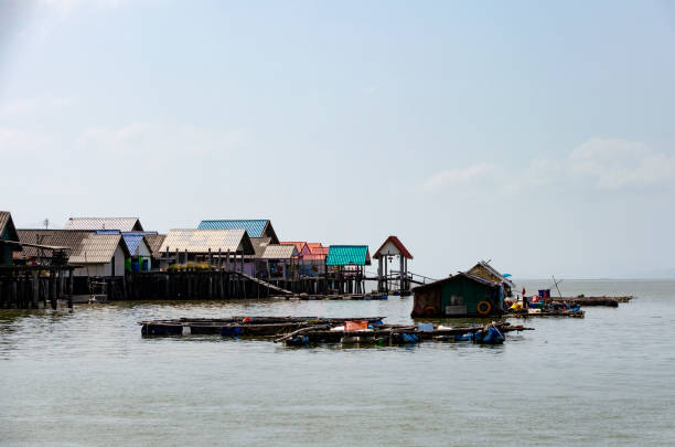 Historical Mon Bridge and center of Sangkhla Buri.  in west Thailand seated at lake and river near to border to Myanmar in Kanchanaburi province and northern Khao Laem national Park. People are on bridge in  background. In background are buildings on hills
