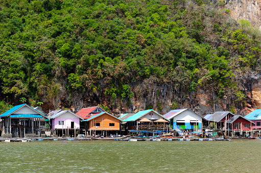 A captivating image of the Floating Village in Ao Phang Nga National Park, where stilted houses and structures sit atop tranquil waters. This unique community, nestled among stunning limestone karsts and emerald seas, highlights the traditional lifestyle harmoniously intertwined with the natural beauty of the region.