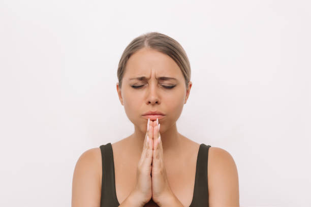 istock A young woman praying with her eyes closed and folded hands, thanking, making wish, asking help 1890435159