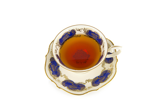Tea in a porcelain vintage cup isolated on a white background.