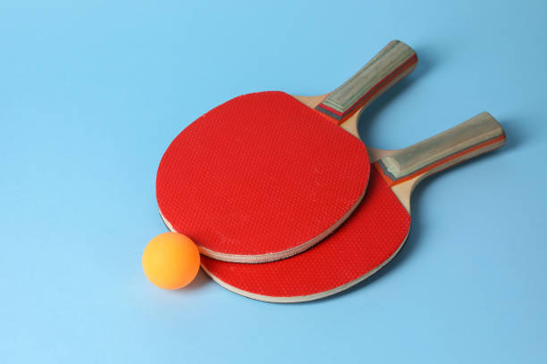 istock Ping pong ball and rackets on light blue background 1890473913