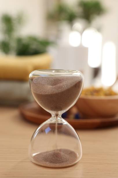 istock Sandglass on wooden table indoors. Spa time 1890478635
