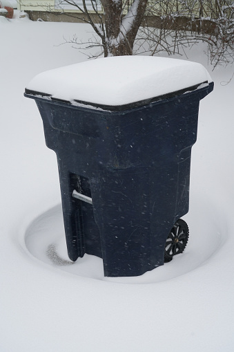 trash bin outdoor in winter blizzard with drift snow