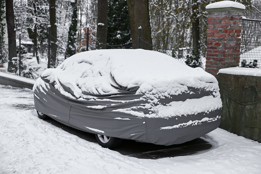Car covered with snow outdoors on winter day