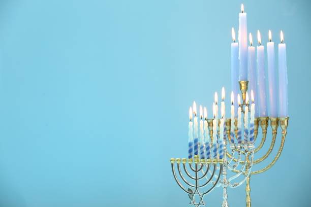 istock Hanukkah celebration. Menorahs with burning candles on light blue background, space for text 1890503597