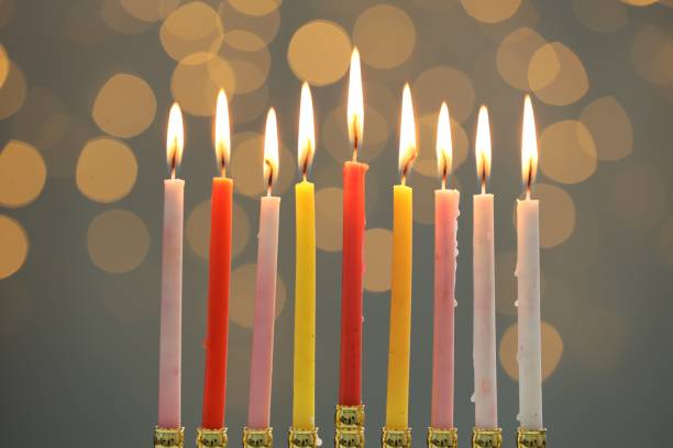 istock Hanukkah celebration. Menorah with burning candles against blurred lights 1890505138
