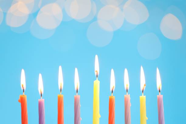 istock Hanukkah celebration. Burning candles on light blue background with blurred lights, space for text 1890505140