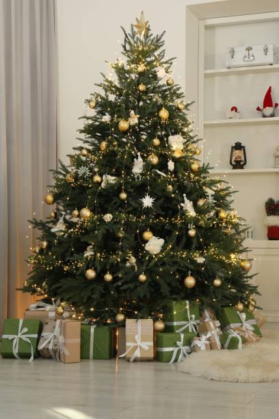 istock Many gift boxes under Christmas tree decorated with ornaments and festive lights in room 1890506160