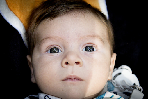 Two month old baby lying on a towel. Happy expression