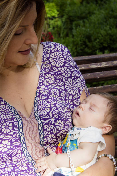 istock Baby sleeping in his mothers arms 1890513444