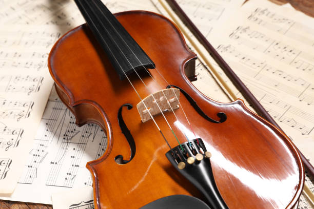 istock Violin, bow and music sheets on table, closeup 1890523517