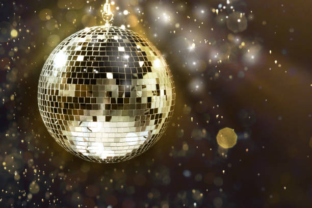 istock Shiny disco ball under golden lights on dark background, space for text. Bokeh effect 1890524883