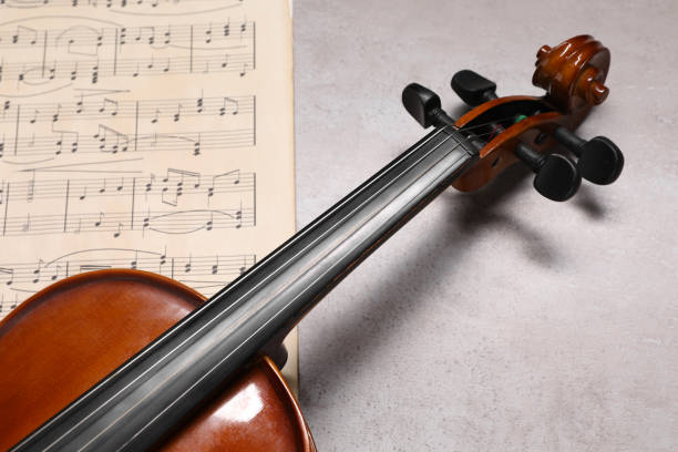 istock Violin and music sheets on grey table, closeup 1890525400