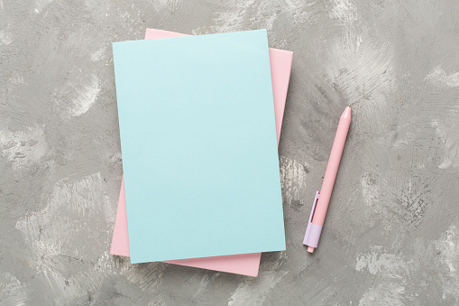 Notebooks with stationery on concrete background, top view