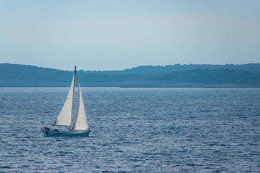 Sailing ship in front of Kornati islands of Croatia blue adriatic sea, green olive trees