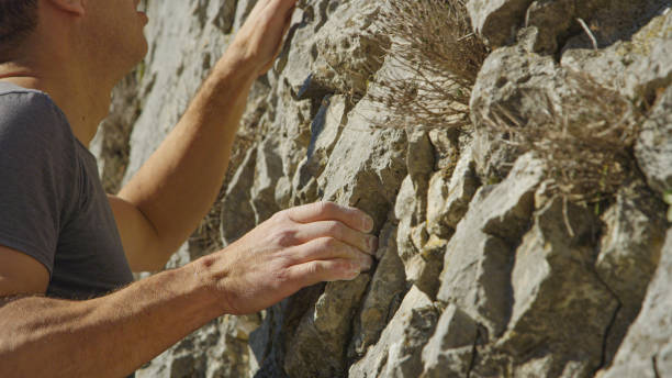 istock CLOSE UP, DOF: Young climber holds his hand firmly while climbing a rocky wall 1890592569