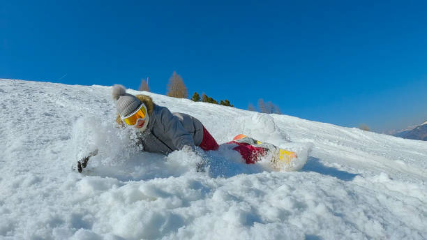 istock Female snowboarder falls after losing balance while making a snowboard turn 1890626231