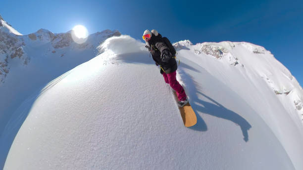 istock PORTRAIT, SELFIE: Lady with a big smile snowboarding on untracked powder snow 1890627334