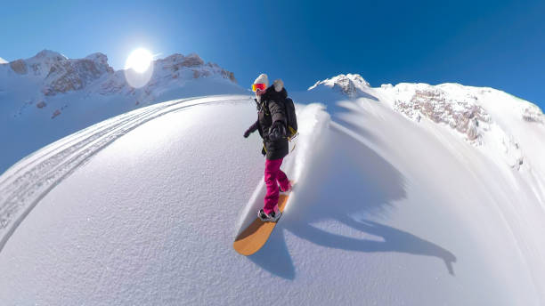istock SELFIE: Young lady smiles as she snowboards down the freshly snowed mountaintop 1890627849