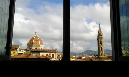 Window view of Florence with famous Duomo Cathederal and Tower in the distance on a bright day.