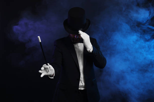 istock Magician holding wand in smoke on dark background 1890656274