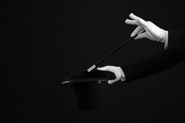 istock Magician showing magic trick with top hat on black background, closeup 1890657830