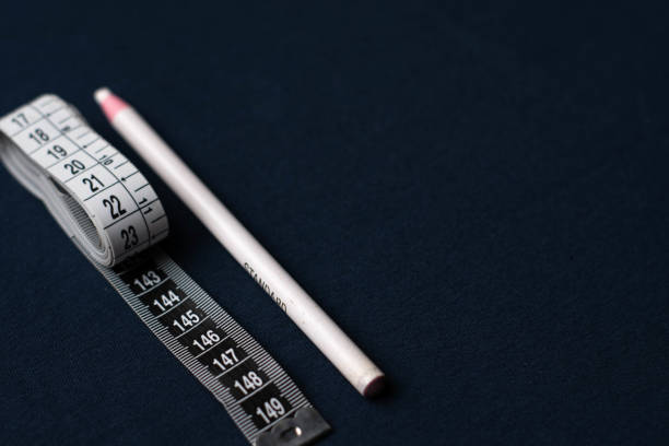 istock sewing pencil with white meter on a dark blue background table 1890658358