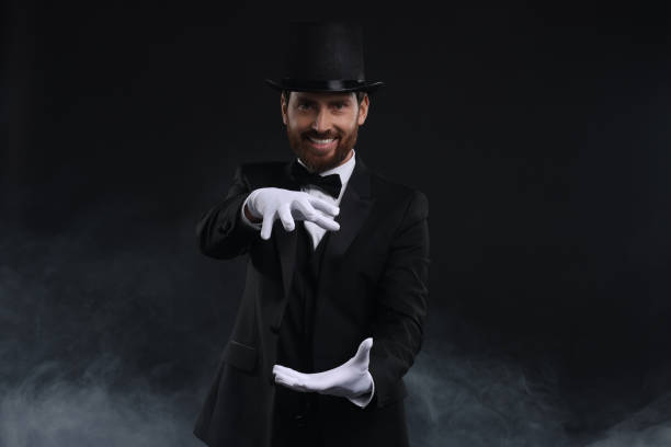 istock Happy magician holding something in smoke on black background 1890658362