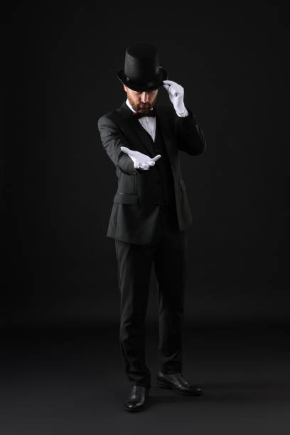 istock Magician in top hat on black background 1890659427