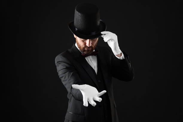 istock Magician in top hat on black background 1890660482