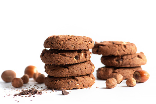 Homemade integral cookies with cereal, hazelnut and chocolate crumbs on white background