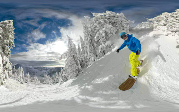 istock PORTRAIT, SELFIE: Young guy riding snowboard through snowy mountain forest 1890670345