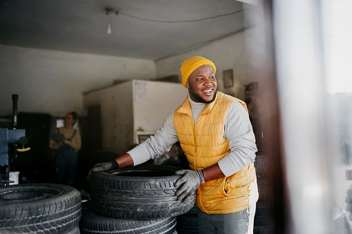 Young handsome man working in his Auto Repair Shop