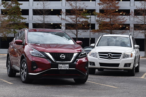 Houston, TX USA 12-26-2023 - A portrait of a red Nissan Murano and a Mercedes-Benz GLK 250 SUV together in the downtown district of Houston, TX