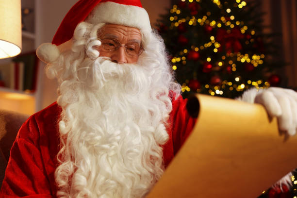 istock Santa Claus reading letter in room with Christmas tree 1890758773
