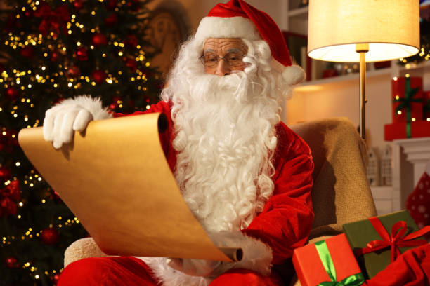istock Santa Claus reading letter in room with Christmas tree 1890759291