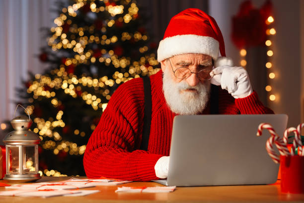 istock Santa Claus using laptop at his workplace in room with Christmas tree 1890760833