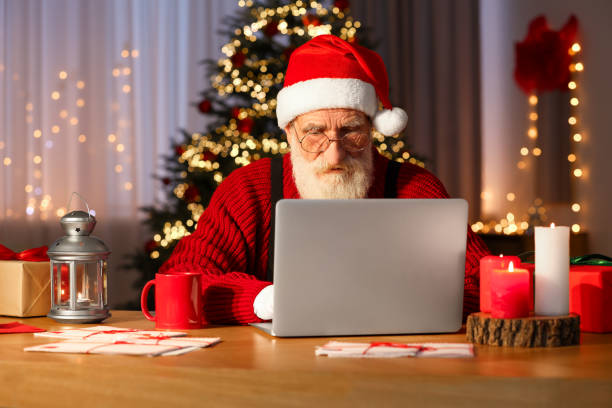istock Santa Claus using laptop at his workplace in room with Christmas tree 1890760837