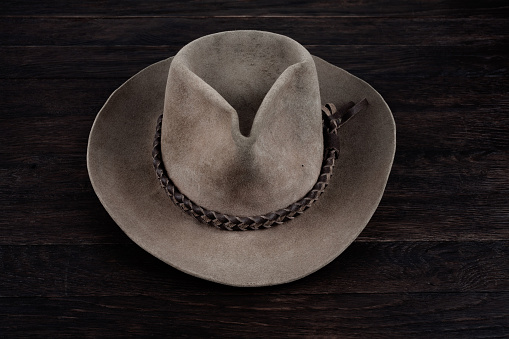 Old west white hat on wooden table.