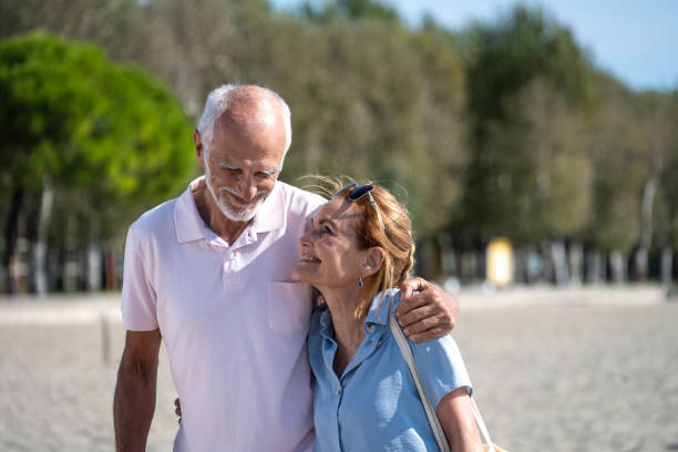istock Laughing senior couple walking on beach 1890798076