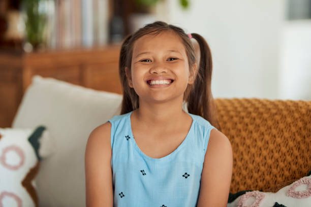 istock Little Girl Sitting On Couch And Smiling 1890894547