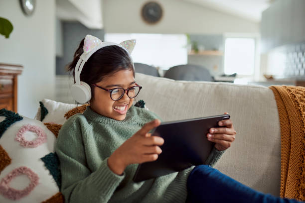 istock Girl wearing headphones and smiling while using a tablet 1890895115