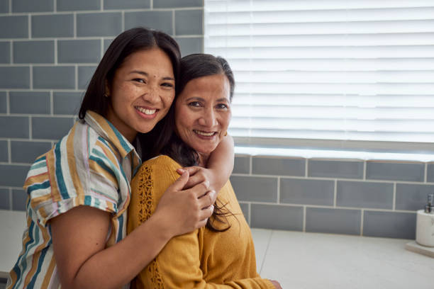 istock Smiling woman hugging her mother in the kitchen. 1890895130