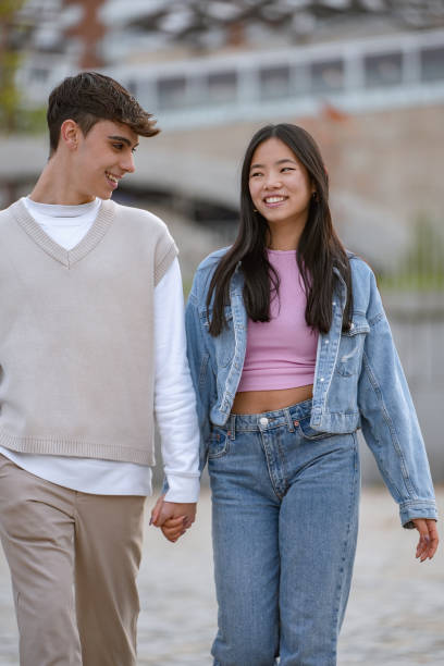 Happy couple holding hands and strolling in an urban environment.