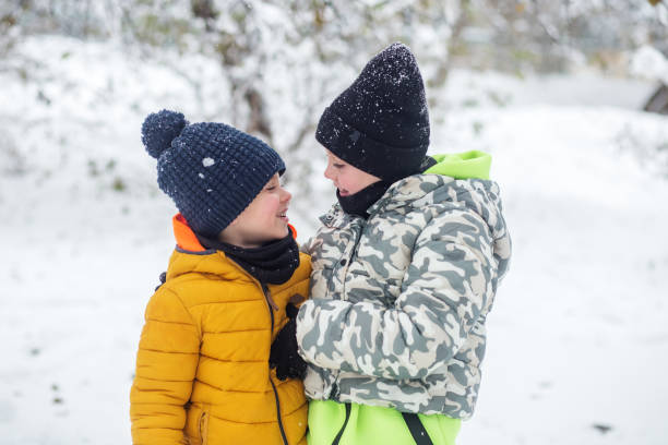 happy children hugging outside in winter. brother and sister together. cold temperature - winter olympic games photos et images de collection