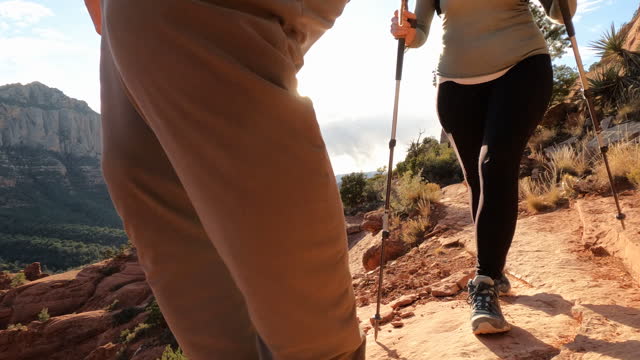 Mature hiking couple explore red rock desert lands