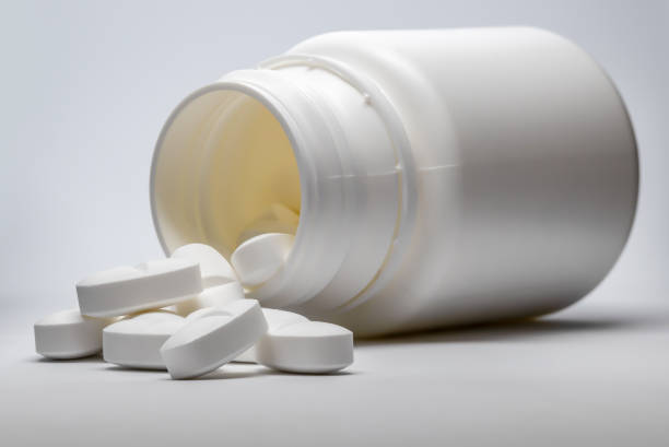 istock Open pill bottle with pills on a very light background. 1890901472