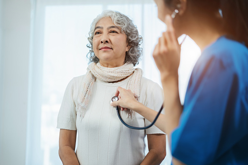 Doctor with stethoscope examining elderly patient with examination, presenting symptoms and recommending treatment, healthcare and medical concept.