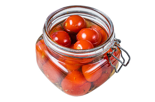 Pickled cherry tomatoes in a glass jar.  Isolated on white background, top view